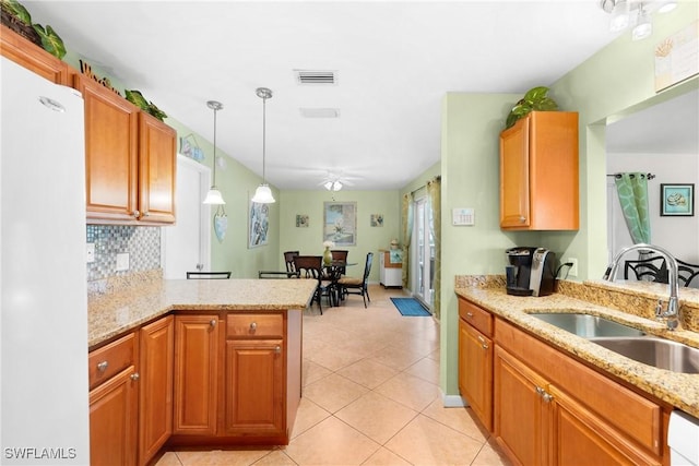 kitchen featuring tasteful backsplash, white appliances, a sink, visible vents, and a peninsula