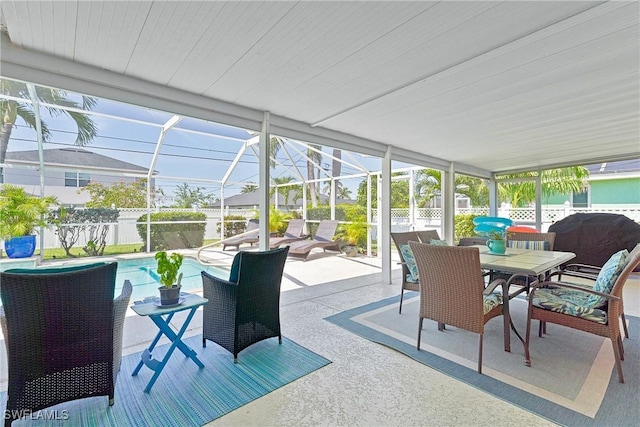 sunroom featuring outdoor dining area and a wealth of natural light