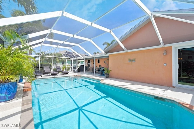 pool featuring glass enclosure and a patio area