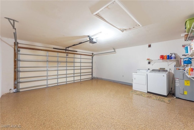 garage featuring independent washer and dryer, electric water heater, and a garage door opener