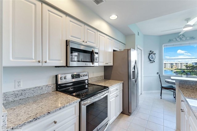 16605 Lake Circle Dr Unit 337, Fort Myers, FL 33908 - kitchen featuring a ceiling fan, light stone counters, appliances with stainless steel finishes, white cabinets, and light tile patterned floors