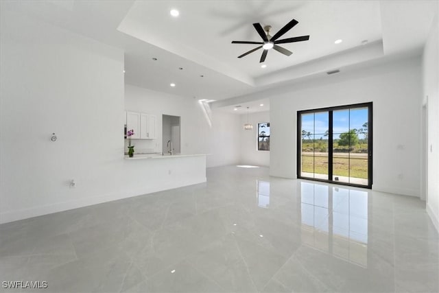 9020 S Casa Ct, Labelle, FL 33935 - unfurnished living room featuring a raised ceiling, baseboards, and ceiling fan
