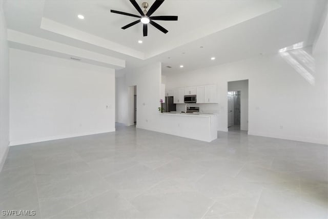 9020 S Casa Ct, Labelle, FL 33935 - unfurnished living room with a ceiling fan, baseboards, a high ceiling, recessed lighting, and a raised ceiling