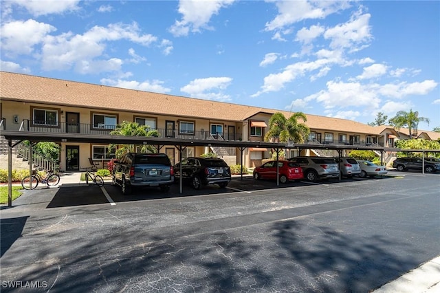 view of building exterior featuring covered parking and a residential view