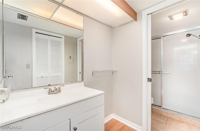 bathroom with visible vents, vanity, and a shower stall