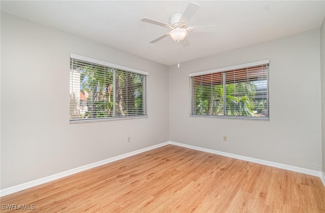 unfurnished room with a wealth of natural light, light wood-type flooring, and baseboards