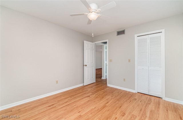 unfurnished bedroom with visible vents, baseboards, a closet, and light wood-style flooring
