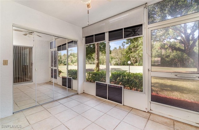 unfurnished sunroom featuring ceiling fan