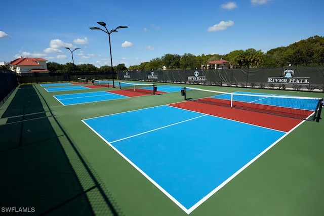 view of tennis court featuring community basketball court and fence