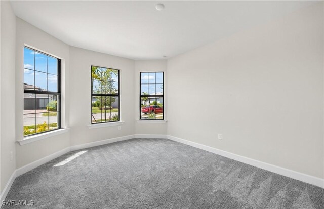 carpeted spare room with baseboards