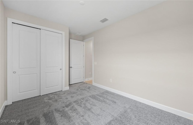 unfurnished bedroom with visible vents, carpet, baseboards, and a closet
