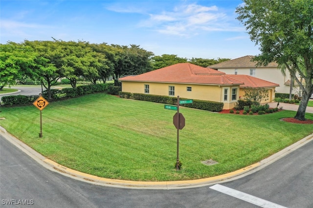 13800 Farnese Dr, Estero, FL 33928 - view of front facade featuring a front lawn, stucco siding, and a tile roof