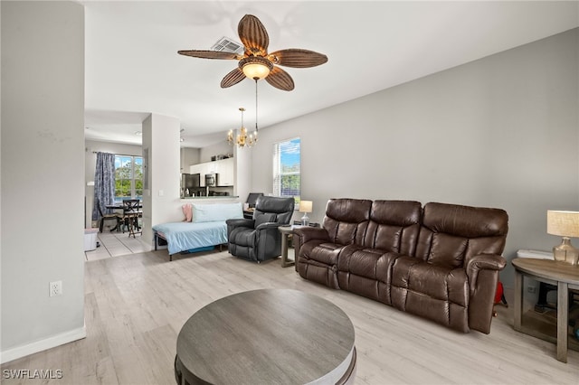 3627 Pine Oak Cir Unit 101, Fort Myers, FL 33916 - living room with light wood-style floors, a ceiling fan, and a chandelier