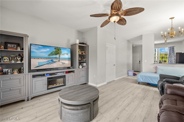 3627 Pine Oak Cir Unit 101, Fort Myers, FL 33916 - living room featuring light wood-style floors, ceiling fan, a chandelier, baseboards, and a glass covered fireplace