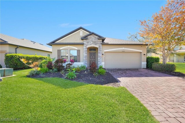 view of front of property with stone siding, decorative driveway, an attached garage, a front yard, and stucco siding
