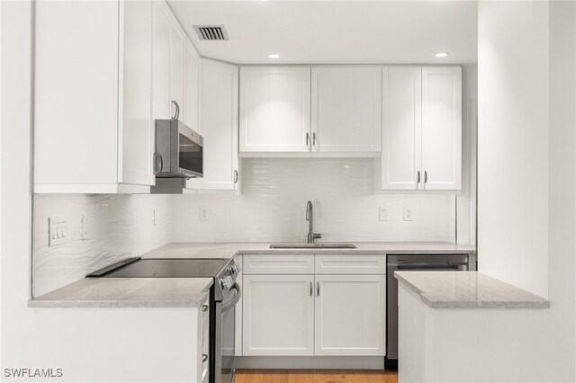 13 Knights Bridge Rd Unit A49, Naples, FL 34112 - kitchen featuring a sink, stainless steel appliances, white cabinetry, backsplash, and recessed lighting