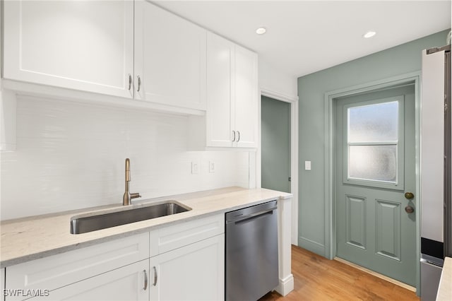 13 Knights Bridge Rd Unit A49, Naples, FL 34112 - kitchen featuring stainless steel dishwasher, a sink, backsplash, white cabinetry, and light wood-style flooring
