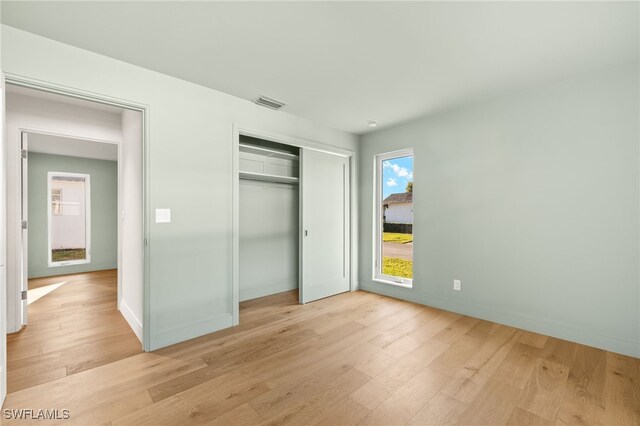 13 Knights Bridge Rd Unit A49, Naples, FL 34112 - unfurnished bedroom featuring light wood-style flooring, a closet, and baseboards
