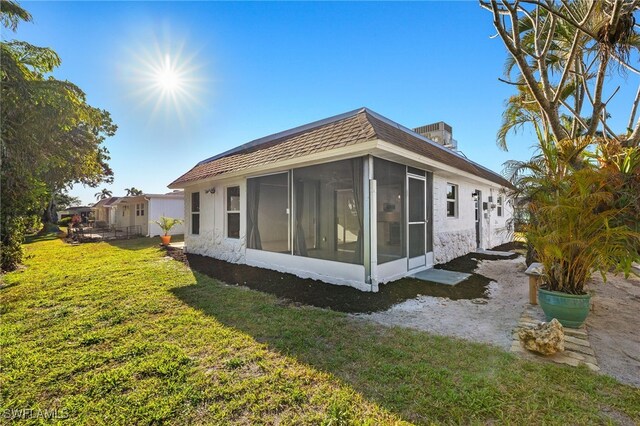 13 Knights Bridge Rd Unit A49, Naples, FL 34112 - view of side of property with a sunroom and a lawn