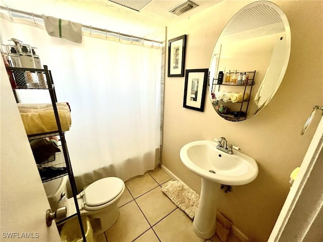 full bathroom featuring baseboards, visible vents, a sink, tile patterned flooring, and toilet