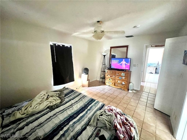 bedroom featuring light tile patterned flooring, visible vents, ceiling fan, and baseboards