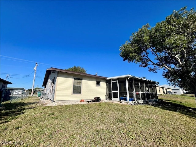 back of house with a yard, fence, and a sunroom