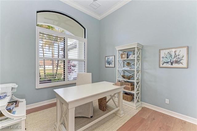 office area with light wood-type flooring, baseboards, visible vents, and ornamental molding