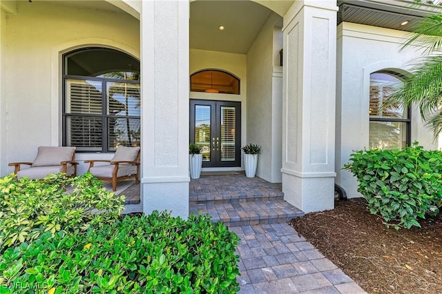 property entrance featuring stucco siding and french doors