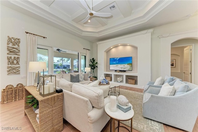 living area with visible vents, ceiling fan, ornamental molding, wood finished floors, and coffered ceiling