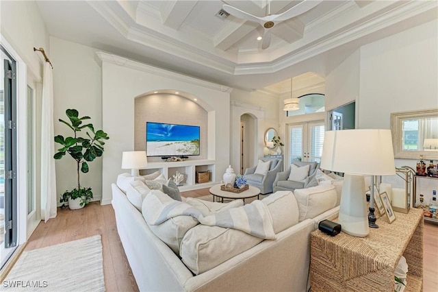 living area featuring light wood finished floors, coffered ceiling, french doors, and ornamental molding
