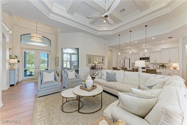 living room with coffered ceiling, a towering ceiling, arched walkways, crown molding, and ceiling fan