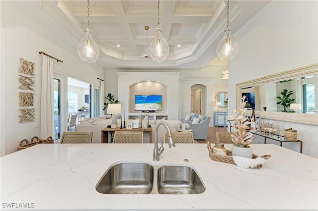 kitchen featuring coffered ceiling, a sink, pendant lighting, beamed ceiling, and open floor plan