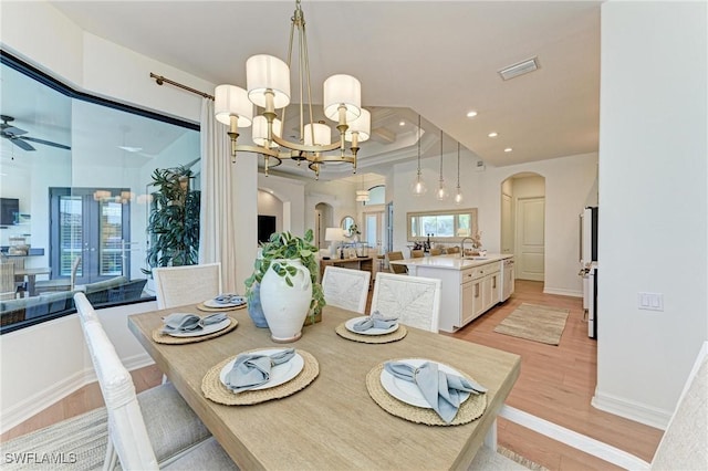 dining room with visible vents, recessed lighting, arched walkways, ceiling fan with notable chandelier, and light wood-type flooring