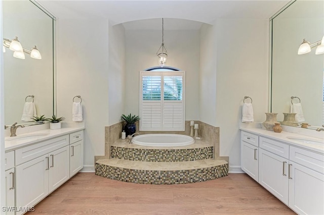 full bathroom with wood finished floors, two vanities, and a sink