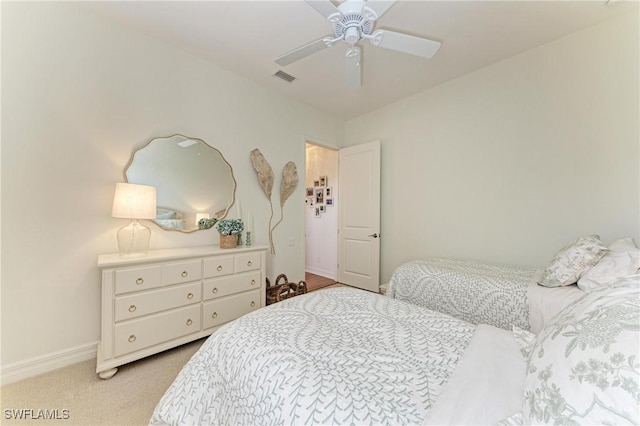 bedroom with a ceiling fan, baseboards, visible vents, and light carpet