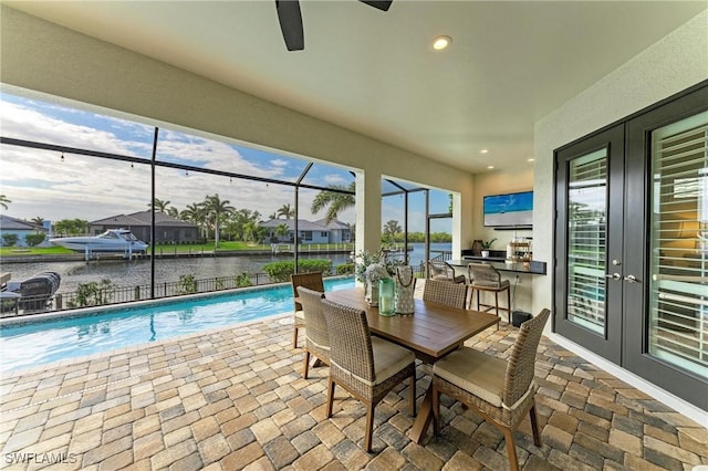 sunroom featuring a swimming pool, ceiling fan, and french doors