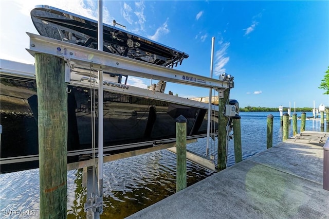 dock area featuring boat lift and a water view