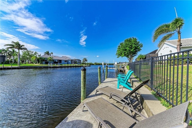 dock area featuring a residential view, fence, and a water view