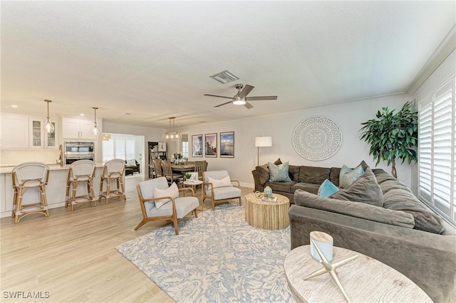621 Trabue Ave, Punta Gorda, FL 33950 - living room featuring a ceiling fan, a textured ceiling, light wood-style floors, and visible vents