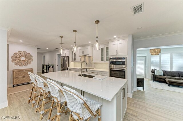 621 Trabue Ave, Punta Gorda, FL 33950 - kitchen with white cabinets, visible vents, light countertops, stainless steel appliances, and a spacious island