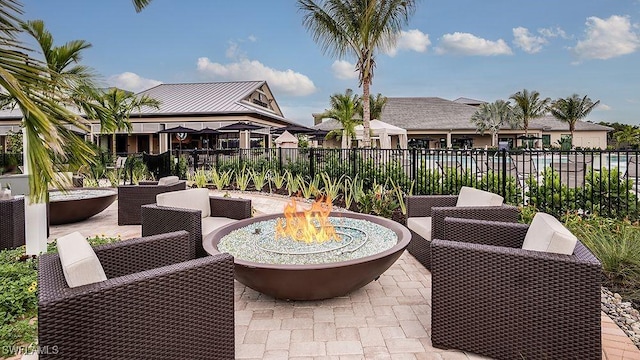 view of patio / terrace with an outdoor living space with a fire pit and fence
