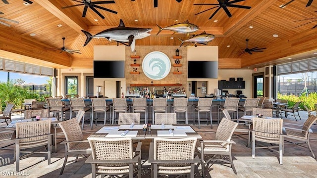 dining space featuring wooden ceiling, high vaulted ceiling, stone finish flooring, and ceiling fan
