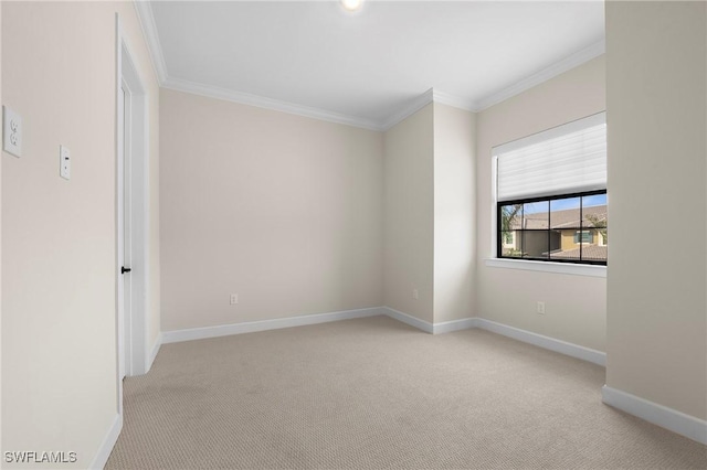 spare room with baseboards, crown molding, and carpet floors