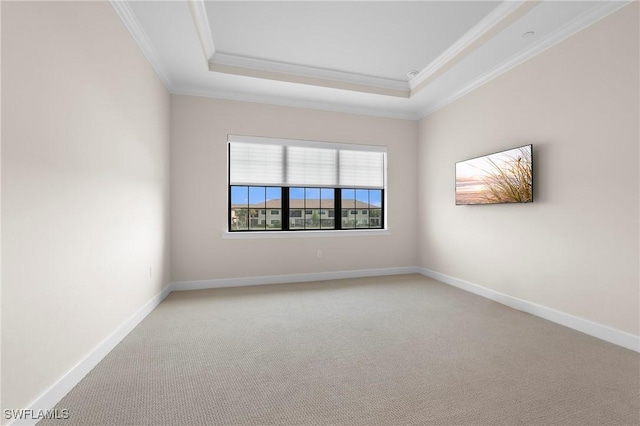 unfurnished room with baseboards, crown molding, and a raised ceiling