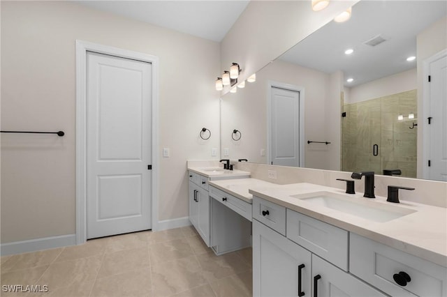 bathroom featuring double vanity, a sink, a stall shower, and baseboards