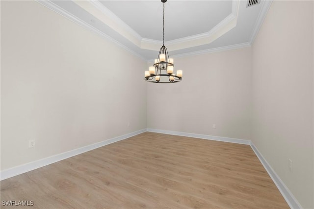 unfurnished room with light wood-style flooring, a tray ceiling, baseboards, and a chandelier