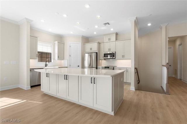 kitchen featuring light countertops, light wood-style flooring, visible vents, stainless steel appliances, and a large island