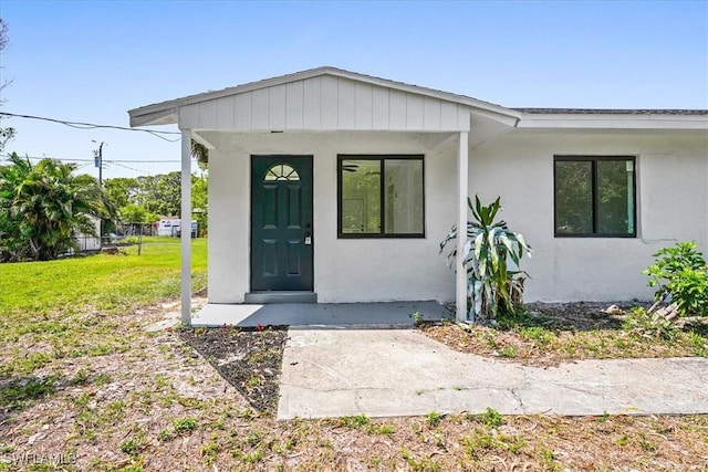 3652 Hibiscus Ave, Naples, FL 34104 - view of exterior entry with a lawn and stucco siding