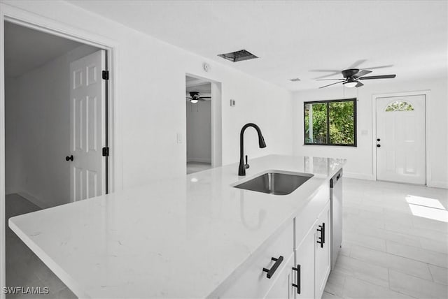 3652 Hibiscus Ave, Naples, FL 34104 - kitchen featuring light stone counters, white cabinetry, ceiling fan, a sink, and dishwasher