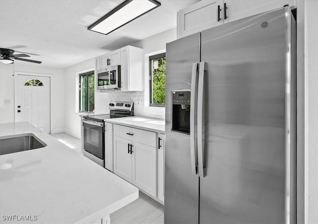 3652 Hibiscus Ave, Naples, FL 34104 - kitchen with tasteful backsplash, appliances with stainless steel finishes, white cabinetry, and ceiling fan